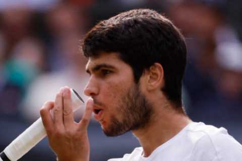 Why do tennis players like Carlos Alcaraz blow on their hands?